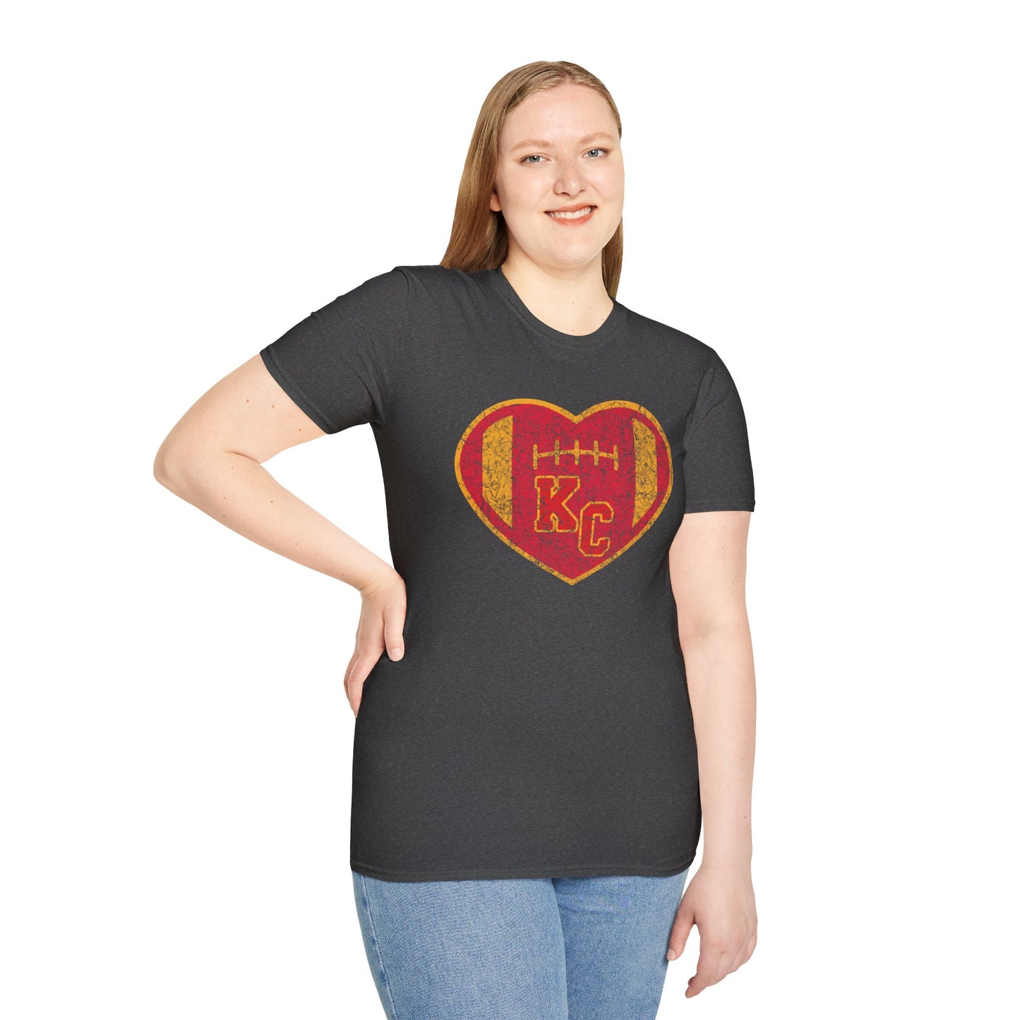 The KC Inspirations Vintage KC Heart Red & Gold - Kansas City Chiefs Inspired T-Shirt is a black T-shirt featuring a heart-shaped design in the center with a red and gold color scheme. Inside the heart is a football and the letters "KC," symbolizing Kansas City football. The vintage KC Heart design has distressed graphics, giving it an authentic, worn-in look.