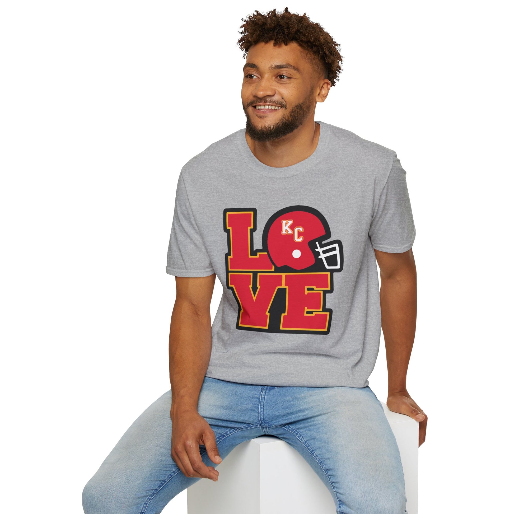 This black LOVE KC - Modern - Kansas City Chiefs Inspired T-Shirt by KC Inspirations features the word "LOVE" in large, bold red and yellow letters. The "O" is replaced by a red football helmet with a white facemask and "KC" on it, making it perfect fan gear for any Kansas City Chiefs supporter.