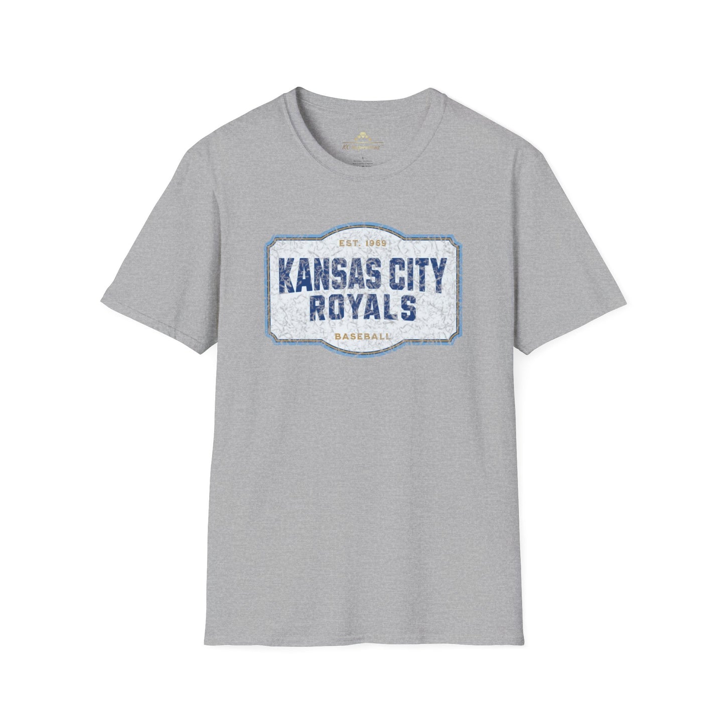 A light blue T-shirt with a graphic label in the center displaying "Kansas City Royals Baseball" in bold blue letters. The text "Est. 1969" is shown above the main text, giving it a vintage throwback look. Perfect for showing team spirit, this distressed T-shirt, Royal Badge - Kansas City Royals Inspired T-Shirt by KC Inspirations, is displayed on a white background.