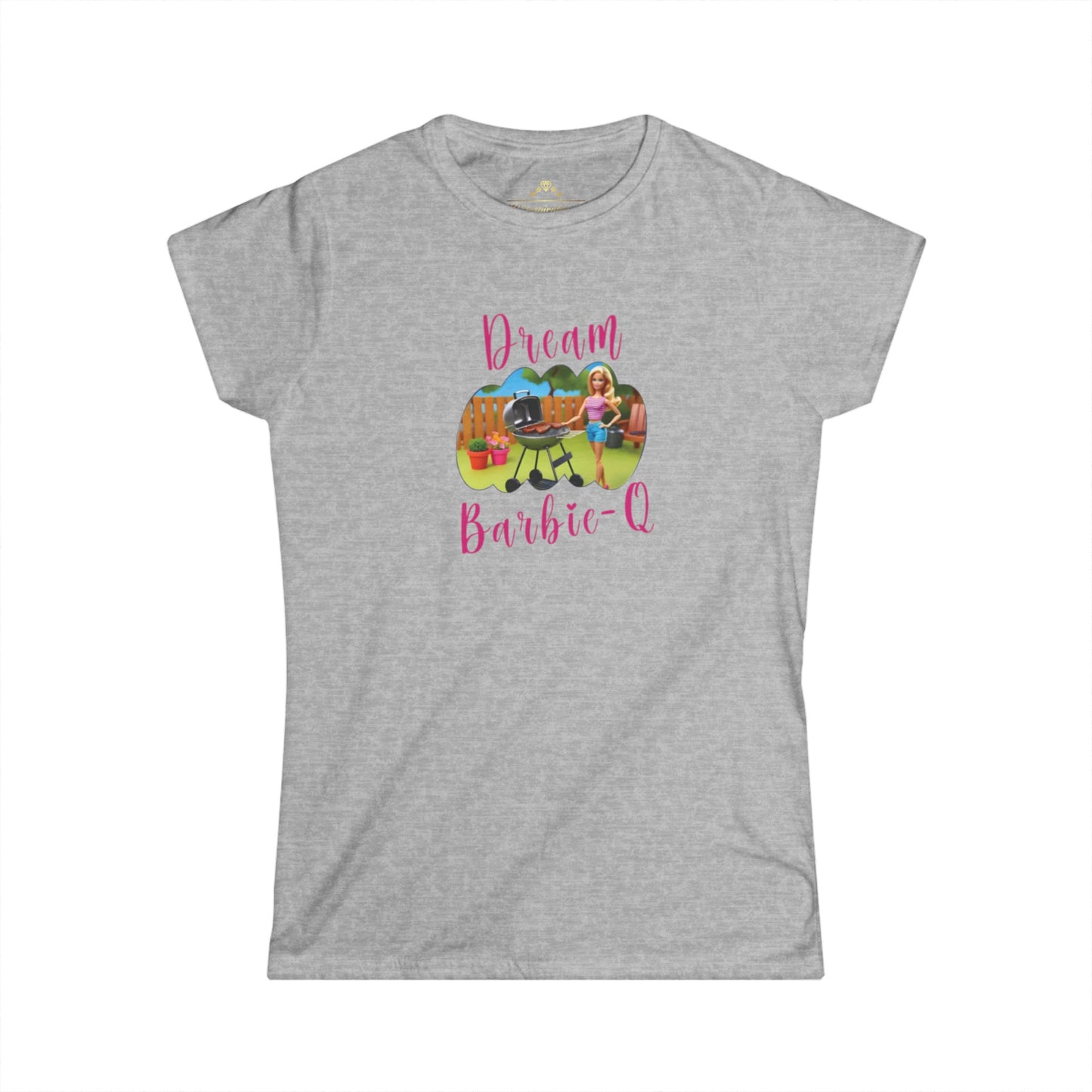 This Dream Barbie-Q - K.C. BBQ Inspired Women's T-Shirt by KC Inspirations is a light blue T-shirt featuring an illustration of a girl beside a grill with food, set against a playful outdoor background. Above the image, "Dream" is written in colorful letters and below it, "Barbie-Q" in whimsical pink font—perfect for fans of Kansas City BBQ.