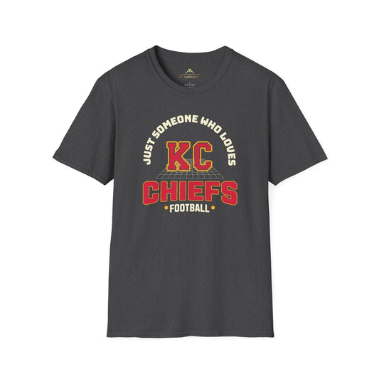 A dark gray t-shirt with the text "Just Someone Who Loves KC Chiefs Football" printed in bold yellow and red letters on the front, perfect for showing off your Chiefs pride. This Just Someone Who Loves - Kansas City Chiefs Inspired T-Shirt by KC Inspirations is a must-have for any fan.