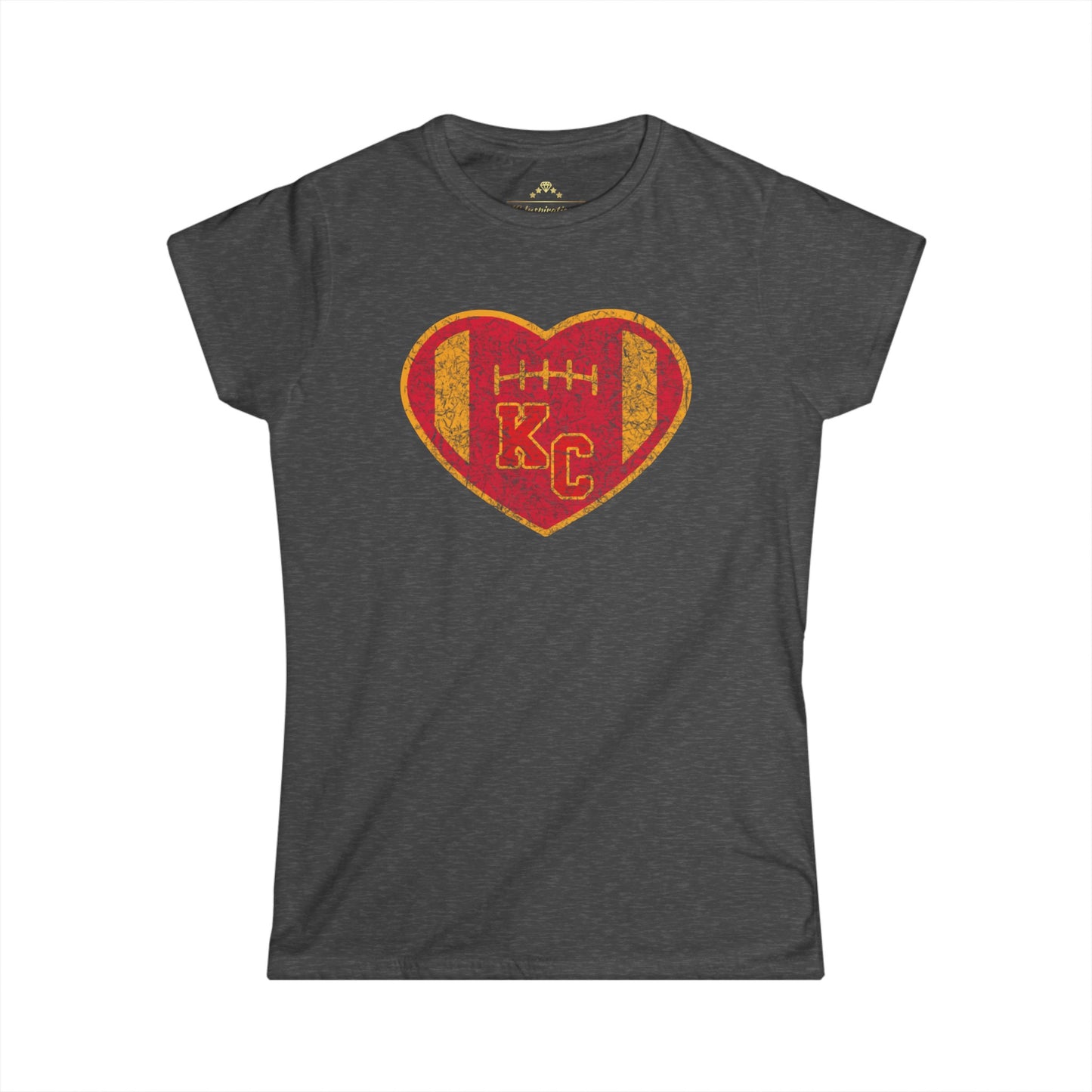 A dark gray women's T-shirt featuring a distressed heart-shaped design in the center. The heart, styled like a football with stitching details, is colored in red and gold. Inside the heart, the letters "KC" are prominently displayed in red with a yellow border. Perfect for Kansas City Chiefs fans! This is the Vintage KC Heart Red & Gold - Kansas City Chiefs Inspired Women's T-Shirt from KC Inspirations.