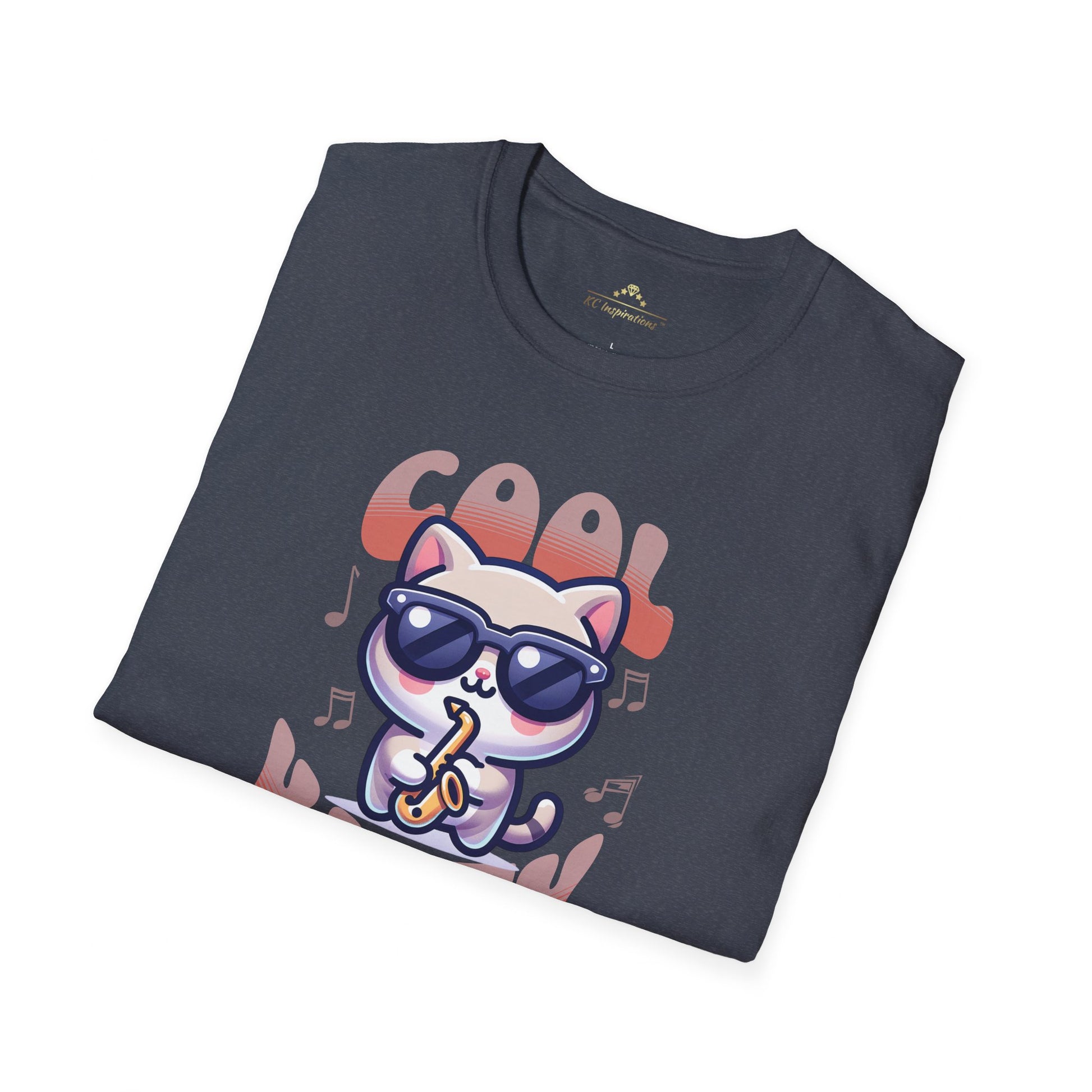 A dark gray t-shirt featuring an illustration of a cat wearing sunglasses and playing a saxophone, surrounded by musical notes. The text "Cool Kitty" is displayed in colorful, bubble-style letters above and below the cat. The product name is Cool Kitty Jazz - KC Jazz Inspired T-Shirt from Printify.