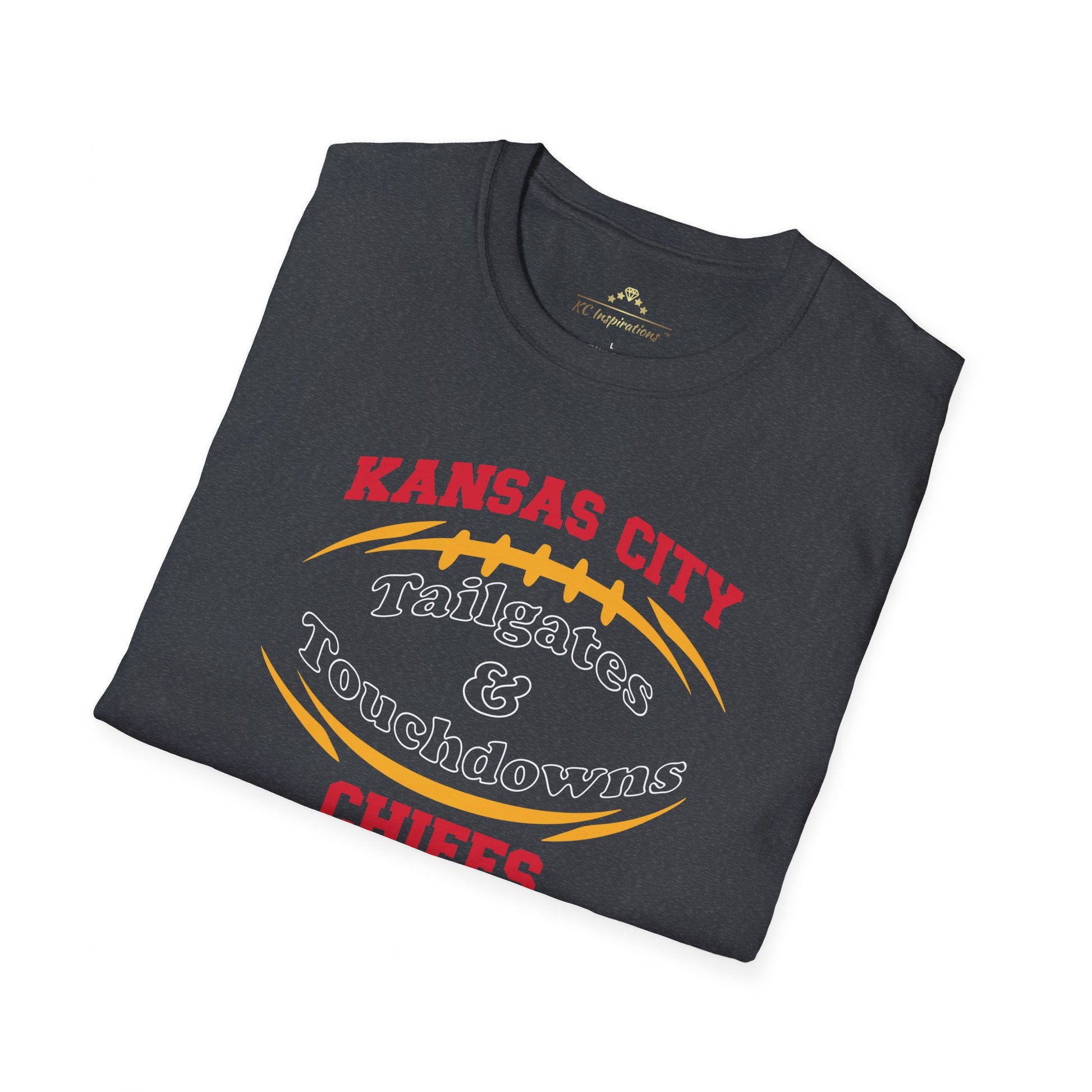 A dark gray Kansas City Chiefs t-shirt with "Kansas City Tailgates & Touchdowns Chiefs" written in bold red and yellow letters. The text is designed within the outline of a football, with "Chiefs" prominently featured at the bottom—perfect game day attire to show your team spirit. This is the **Tailgates & Touchdowns - Kansas City Chiefs Inspired T-Shirt** by **KC Inspirations**.