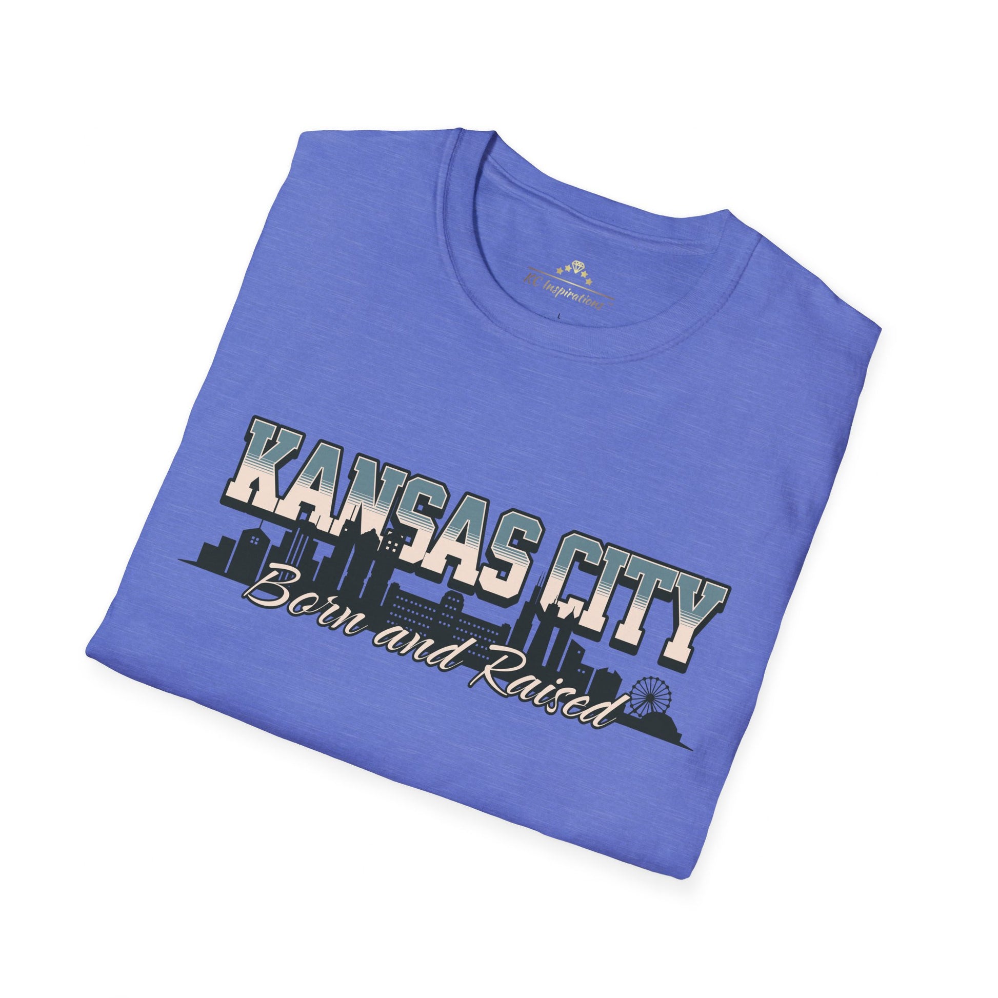 A blue Born And Raised KC - Kansas City Inspired Soft-Style T-Shirt by KC Inspirations with the text "KANSAS CITY Born and Raised" on the front, capturing true hometown pride. The words are set against a graphic of a city skyline.