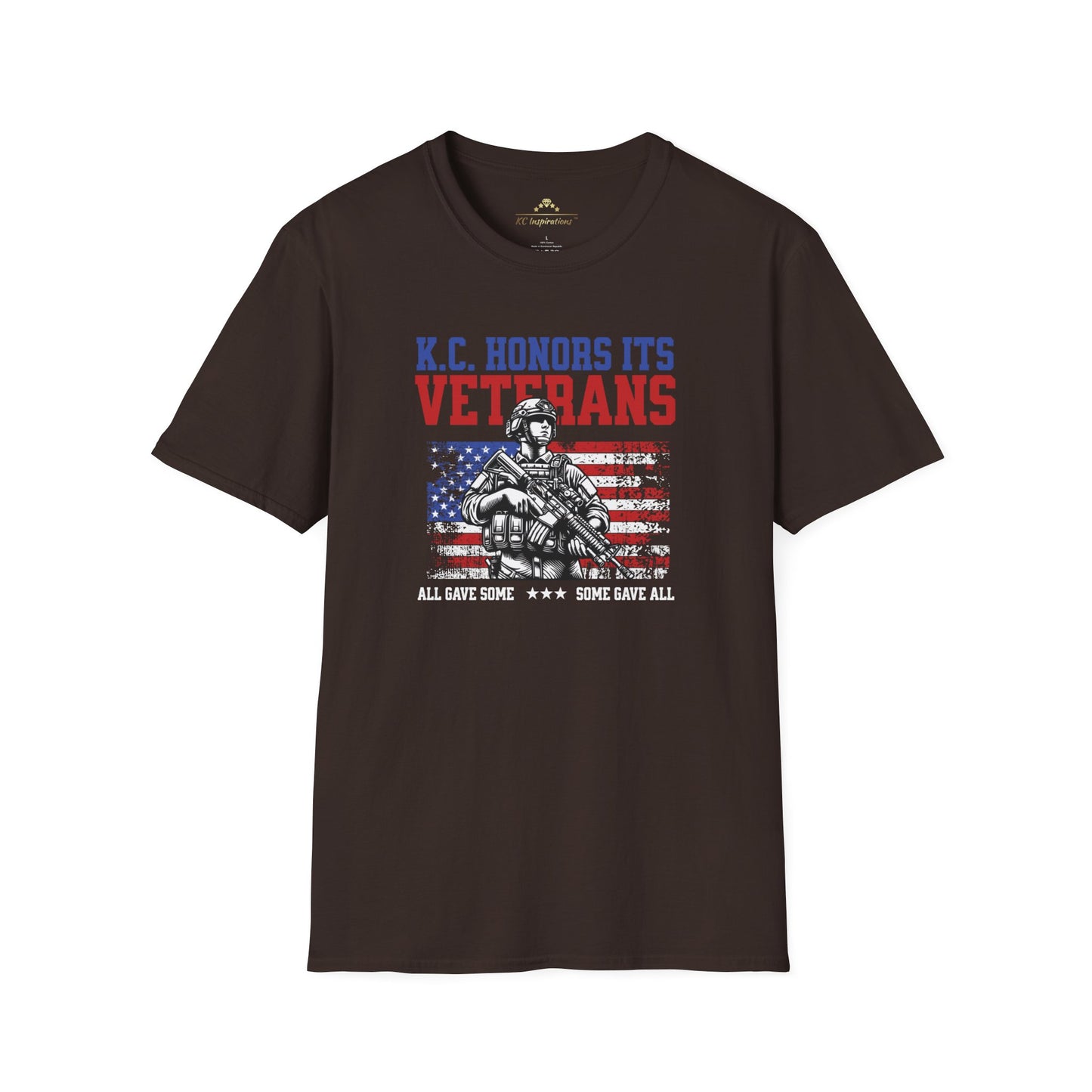 A navy blue KC Honors Its Veterans - Kansas City Inspired T-Shirt featuring a soldier with the American flag in the background. Text above reads "KC Honors Its Veterans," and below it reads "All Gave Some ★★★ Some Gave All." Perfect for showing your support for the veteran community. Brought to you by KC Inspirations.