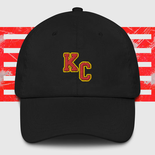 A KC Inspirations KC Red & Gold - Kansas City Chiefs Inspired Cap featuring the embroidered letters "KC" in red and yellow on the front. The background showcases red and white abstract stripes, making it a stylish choice for any Kansas City Chiefs fan.