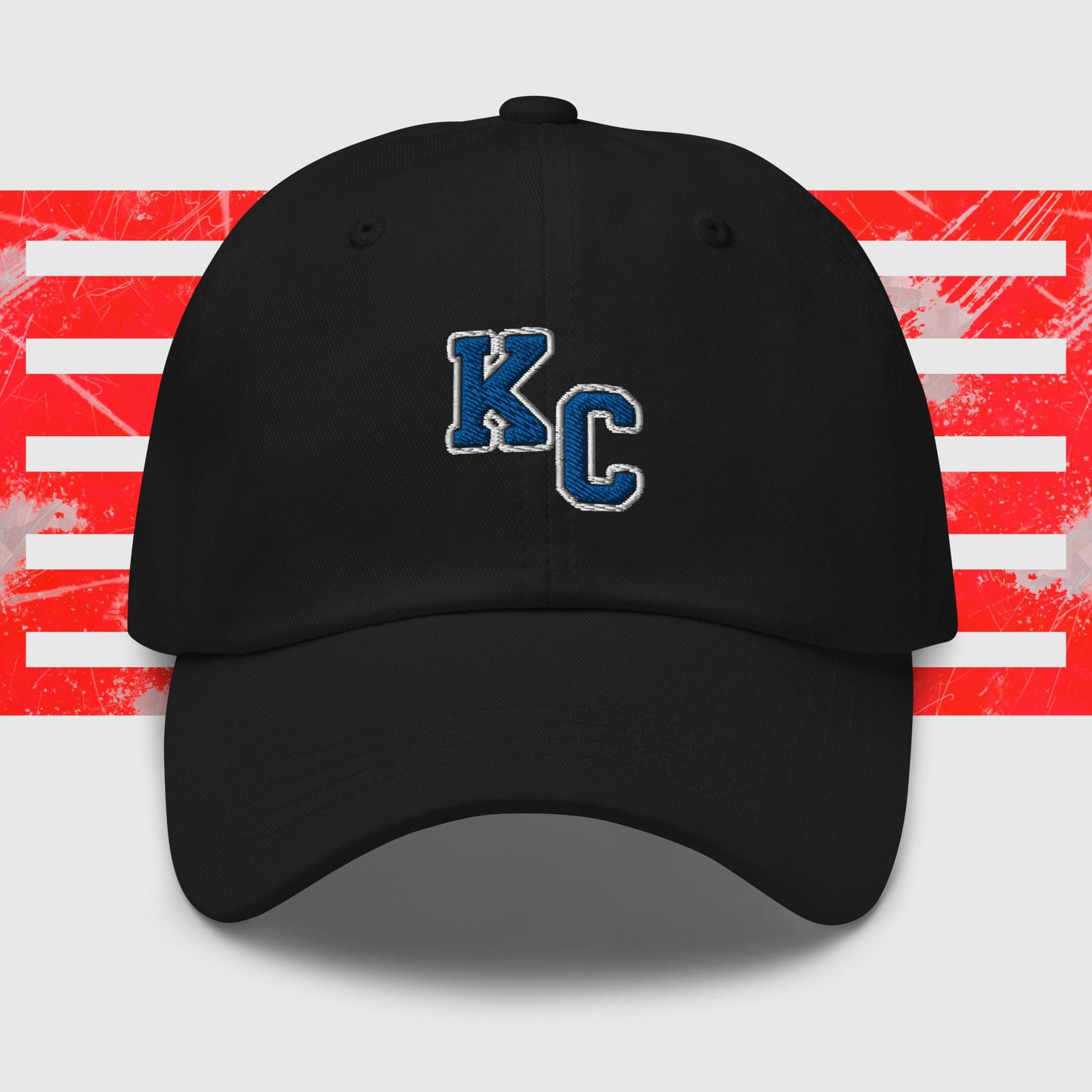 A Blue KC - Kansas City Royals Inspired Cap from KC Inspirations featuring the white block letters "K" and "C" outlined in dark blue on the front. The background includes horizontal red and white stripes with a distressed texture, accentuated by embroidered graphics, making it the perfect dad hat for any fan.