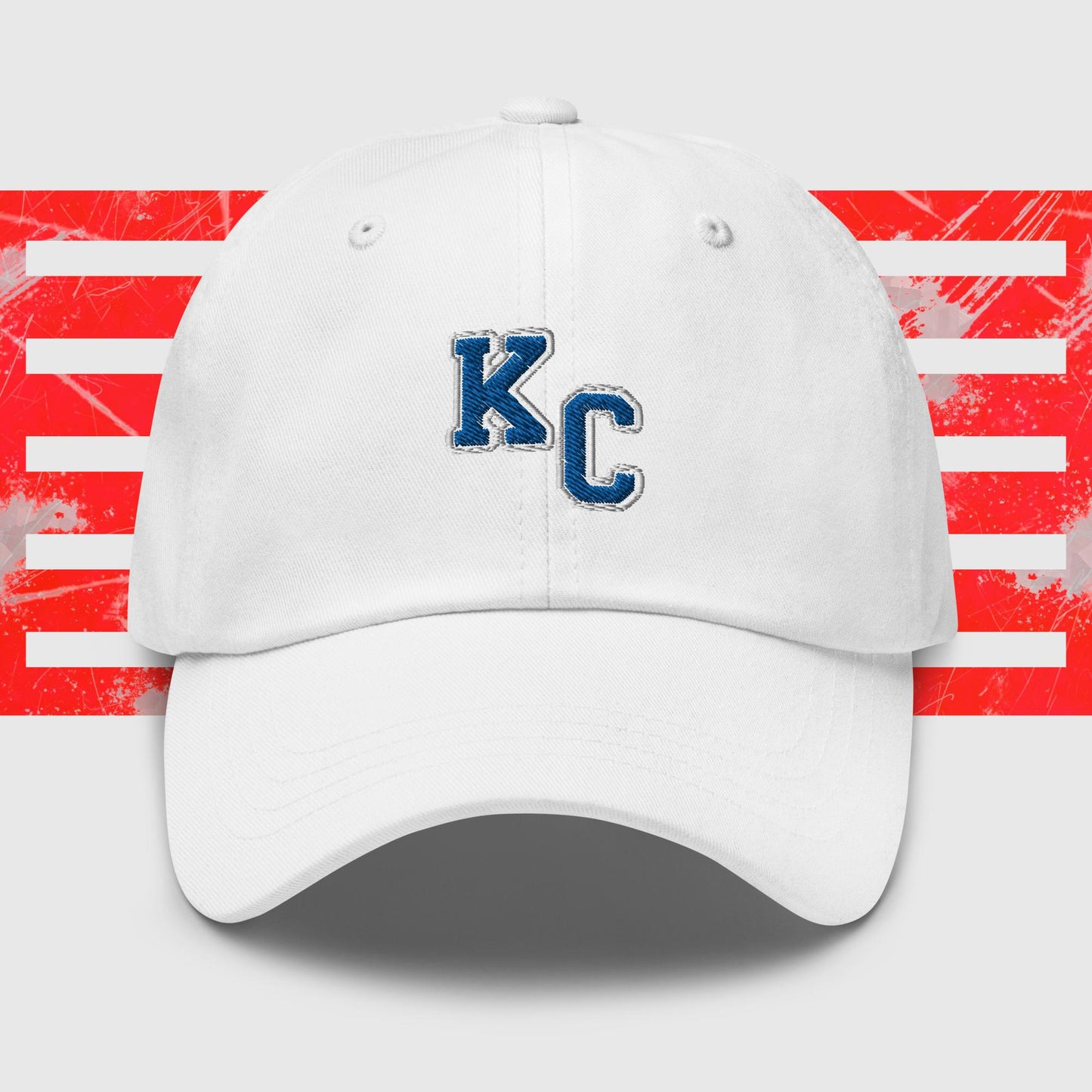 A Blue KC - Kansas City Royals Inspired Cap from KC Inspirations featuring the white block letters "K" and "C" outlined in dark blue on the front. The background includes horizontal red and white stripes with a distressed texture, accentuated by embroidered graphics, making it the perfect dad hat for any fan.